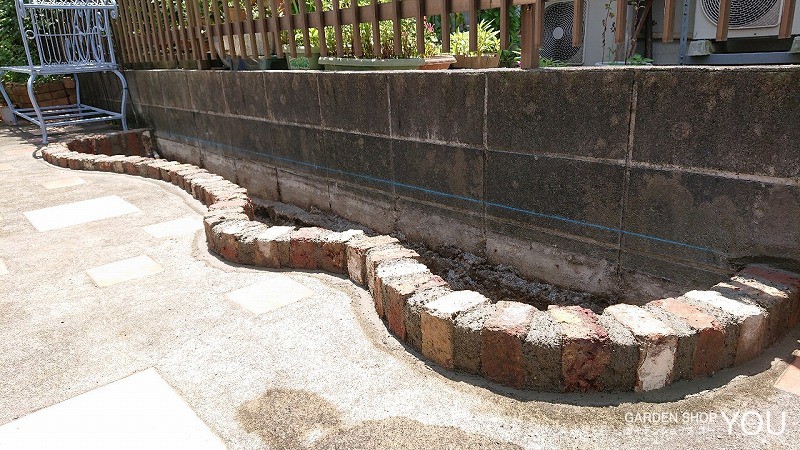 コンクリートをはつってレンガで土留めを。